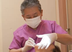 歯の白さを確認する医師と患者のイメージ